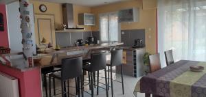 eine Küche mit einer Bar mit Hockern und einem Tisch in der Unterkunft Charmante maison dans village in Champcueil