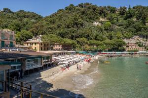 a beach with umbrellas and people on the beach at PETITE PARAGGI Vista e Comodità sul Mare in Santa Margherita Ligure