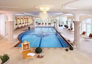 a large swimming pool in a building with a lobby at Der Lärchenhof in Erpfendorf