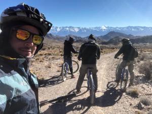 a group of people riding bikes in the desert at Cabañas del globero in Uspallata