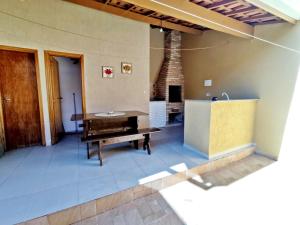 a kitchen with a table and a sink and a fireplace at Casa KAIS Peruíbe in Peruíbe