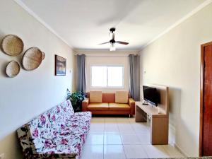 a living room with a couch and a television at Casa KAIS Peruíbe in Peruíbe +32 photos