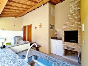 a bathroom with a tub and a tv in a room at Casa KAIS Peruíbe in Peruíbe