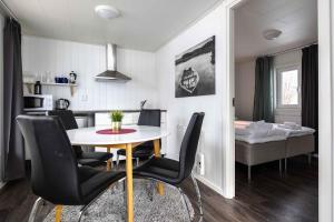 a kitchen and dining room with a table and chairs at Nordic Lapland Frevisören in Båtskärsnäs