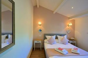a bedroom with two beds and a mirror at Entre 2 eaux in Marseillan +27 photos