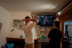 a man standing in a living room playing a video game at Mana Mana Youth Hostel in Tossa de Mar