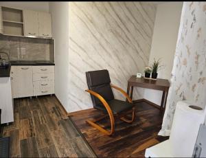 a chair sitting in a kitchen with a table at Casa COCO in Curtea de Argeş