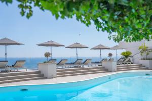 a swimming pool with chairs and umbrellas at Grand Hotel Tritone in Praiano