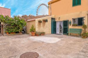 阿尔盖罗Le Antiche Conce的一座有绿色长椅和摩天轮的建筑