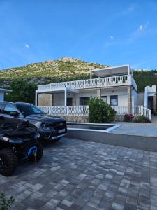 a car and a motorcycle parked in front of a house at Apartman Lidija in Starigrad