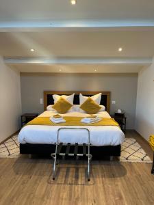 una camera da letto con un grande letto con lenzuola e cuscini gialli di Entre 2 eaux a Marseillan