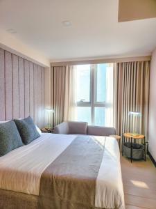 Katil atau katil-katil dalam bilik di LUXESTAYSMNL STYLISH FAMILY 2BR SUITE POOLGYM 400MBPS WIFI NETFLX Amazing City View