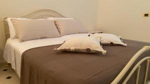 a bed with two pillows on top of it at Al mare da Merida in Savelletri di Fasano