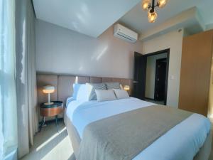 Katil atau katil-katil dalam bilik di LUXESTAYSMNL STYLISH FAMILY 2BR SUITE POOLGYM 400MBPS WIFI NETFLX Amazing City View