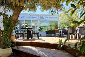 un patio con tavoli e sedie in un ristorante di Entre 2 eaux a Marseillan