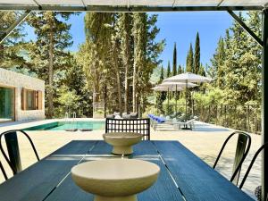 an outdoor table with chairs and a pool at Domenico Morani Luxury Villa Concept with private pool by DadoVillas in Gastourion