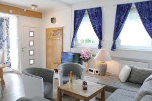 a living room with blue curtains and a couch at City Ferienhaus Vulkaneifel in Daun