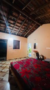 a bedroom with a large bed with red flowers on it at Nakshatra Beach Stay in Gokarn