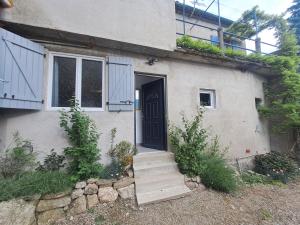 a white house with a black door and stairs at T2 Concoules - Panorama, Randonnées, Etapes motards in Concoules +4 photos