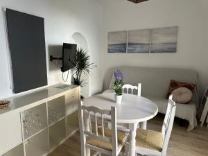una piccola sala da pranzo con tavolo e sedie bianchi di La Casita de Ana a Tarifa Altre 22 foto
