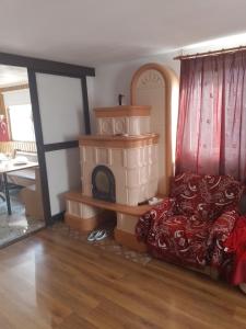 a living room with a bed and a fireplace at Pensiune Colina Farm in Găgeni