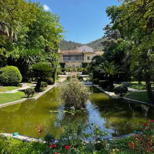 a garden with a pond in front of a building at Villa Rios in Xàtiva