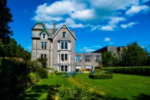 an old stone house with a grass yard at Cumbria Grand Hotel in Grange Over Sands