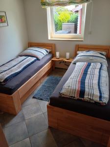 Dos camas en una habitación con ventana. en Ferienhaus Dittrich, en Eckernförde