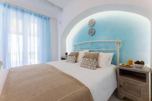 a bedroom with a bed with a blue wall at Velonis Villa with private pool and sea view in Agia Anna Naxos +94 photos