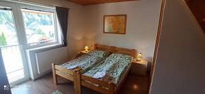 a small bedroom with a bed and a window at Penzión U Jolany in Habovka