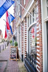 a street with flags and a sign on a building at Hello I'm Local - Boutique Hostel in Haarlem