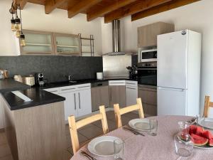 a kitchen with a table and a white refrigerator at Gite au calme à 15 min d'Albi, 7 personnes in Taïx