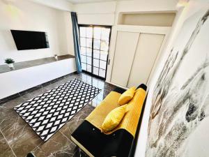 a living room with a yellow couch and a television at Flat Luxuous Praia da Oura in Albufeira