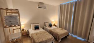 a small room with two beds and a mirror at Apartamento em Itaúna vista para o mar e surf in Saquarema