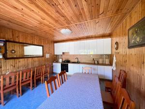 a dining room with a table and chairs and a kitchen at Stanica Przygody in Sztutowo