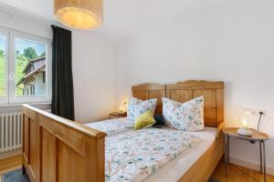 a bedroom with a wooden bed and a window at Moderner Schwarzwaldtraum in Oberharmersbach