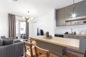 a kitchen and living room with a table and a couch at Anja Apartment in Bečići +4 photos