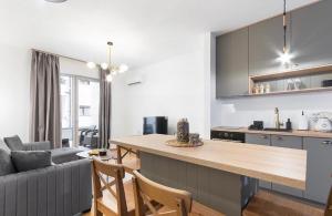 a kitchen and living room with a table and a couch at Anja Apartment in Bečići