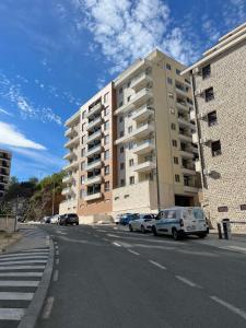 a street with cars parked in front of a building at Anja Apartment in Bečići
