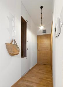 a hallway with white walls and a wooden door at Anja Apartment in Bečići