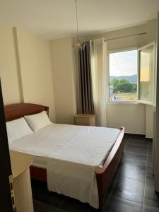 a bedroom with a large bed and a window at Lalez bay Apartment in Durrës