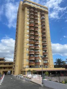 阿罗纳Appartamento los cristianos torres del sol的一栋黄色的大楼，上面有很多阳台