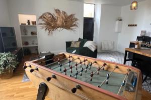 un soggiorno con un grande tavolo da biliardo con di Appartement Le Murmure du Millet a Mortagne-au-Perche