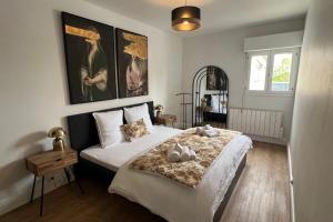 una camera da letto con un letto con due animali di peluche sopra di Appartement Le Murmure du Millet a Mortagne-au-Perche