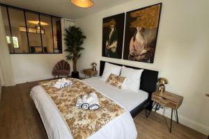 una camera da letto con un letto con asciugamani sopra di Appartement Le Murmure du Millet a Mortagne-au-Perche Altre 12 foto