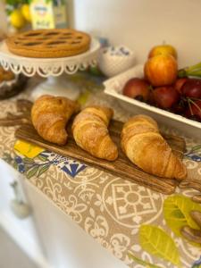 a table with croissants on a cutting board and fruit at Five Apartment B&B in Licata +20 photos