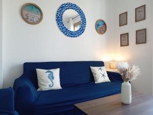ein blaues Sofa im Wohnzimmer mit Spiegel in der Unterkunft L'Attico sul Porto, Sea View with Terrace, Imperia Center in Imperia