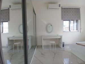 a white room with two tables and two chairs at Shmeisani homes central location near Abdali in Amman +28 photos