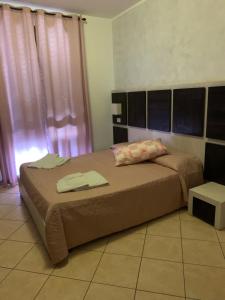 una camera da letto con un letto con due asciugamani sopra di B&B Agrodolce a San Vito lo Capo