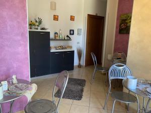 a dining room with tables and chairs and a kitchen at B&B Agrodolce in San Vito lo Capo